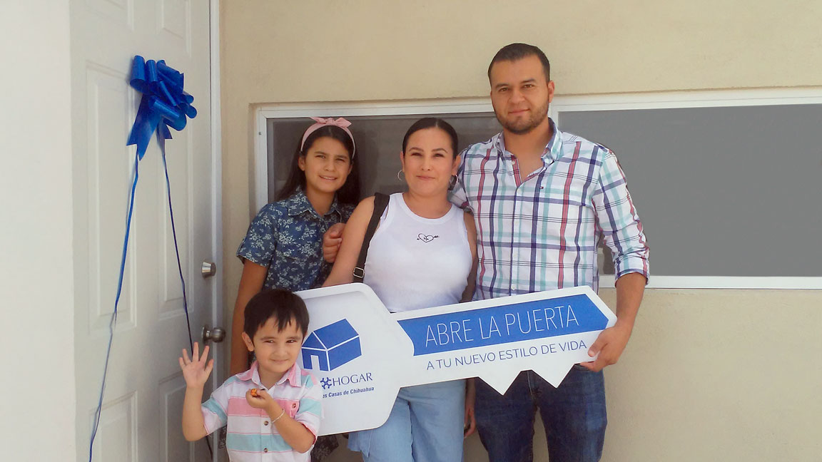 Familia feliz porque acaba de comprar casa. Papá, mamá, mujer adolescente sonrientes y niño saludando a la cámara.