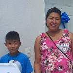 Mamá e hijo de cerca de 8 años recibiendo las llaves de su casa nueva.